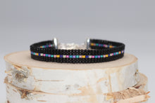Load image into Gallery viewer, dainty black seed bead bracelet with a row of rainbow beads down the middle