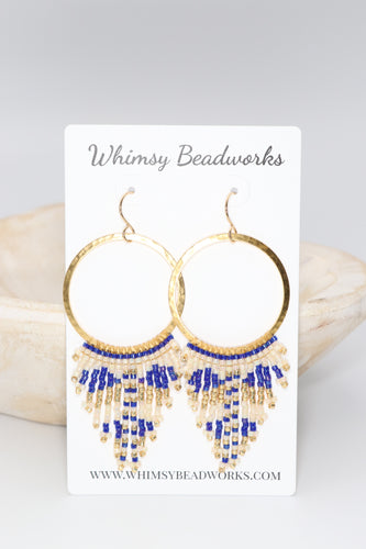 Sapphire blue, gold, and cream seed beads were hand sewn in a southwestern design onto hammered gold metal hoops. 14 k gold filled ear wires. 3 inches long. 1.25 inches wide